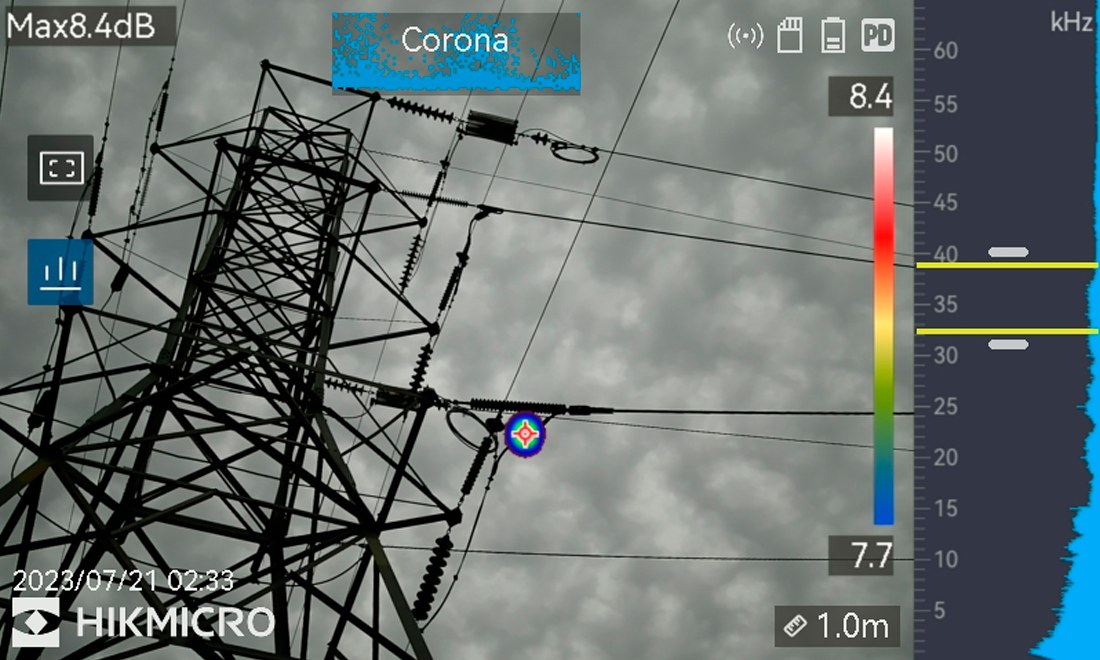 Captura da câmera AI56: descarga parcial do tipo corona identificada em torre de transmissão, com o ponto de emissão marcado sobre a foto real.
